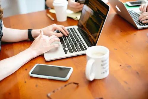 Team collaborating in a modern office with laptops and notes on a table